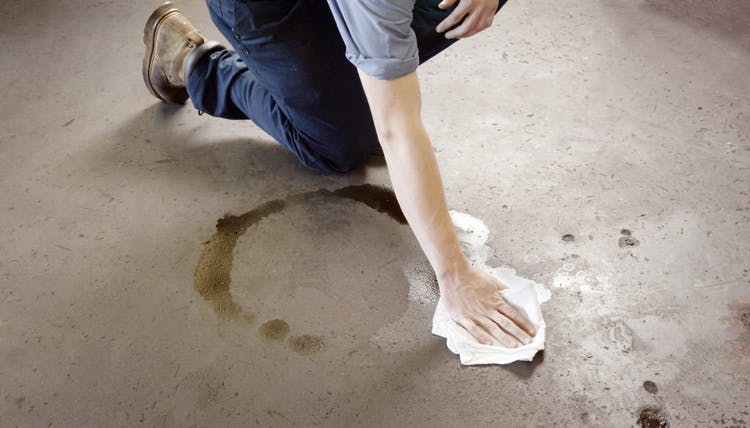 mujer limpiando piso sucio con aceite