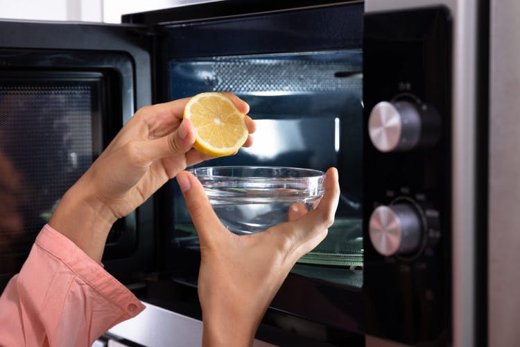 Mujer exprime limón en un recipiente antes de ponerlo en el microondas
