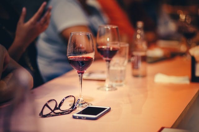 En una cena, la gente bebe vino en copas.