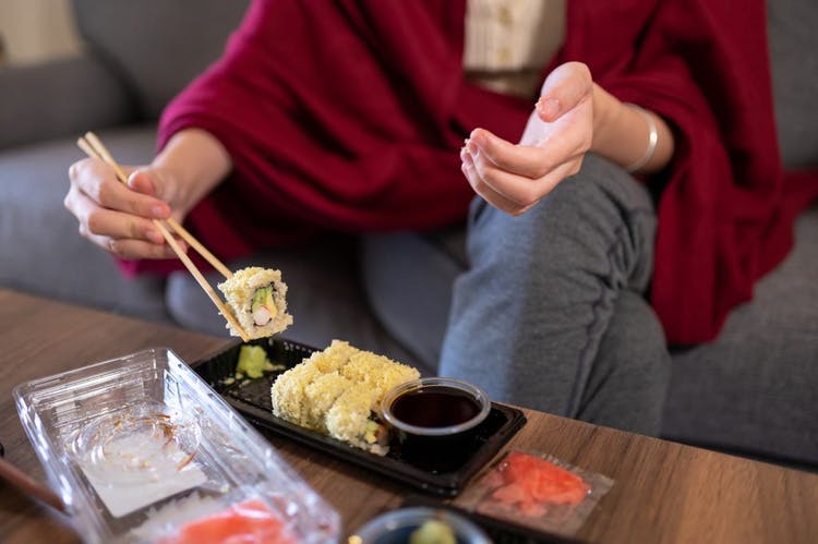 mujer comiendo comida japonesa