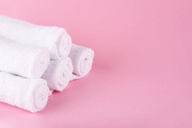 toallas dobladas sobre fondo rosa