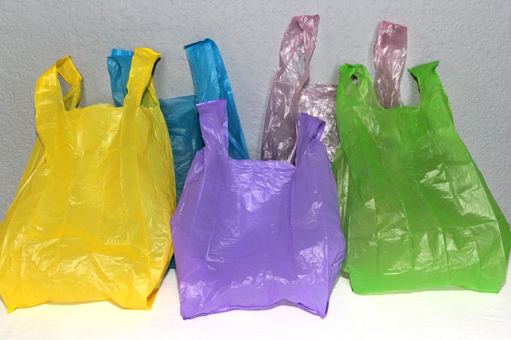 Bolsas de plástico de colores organizadas y colocadas una al lado de la otra.