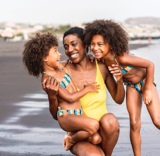 mujer con dos hijas en la playa