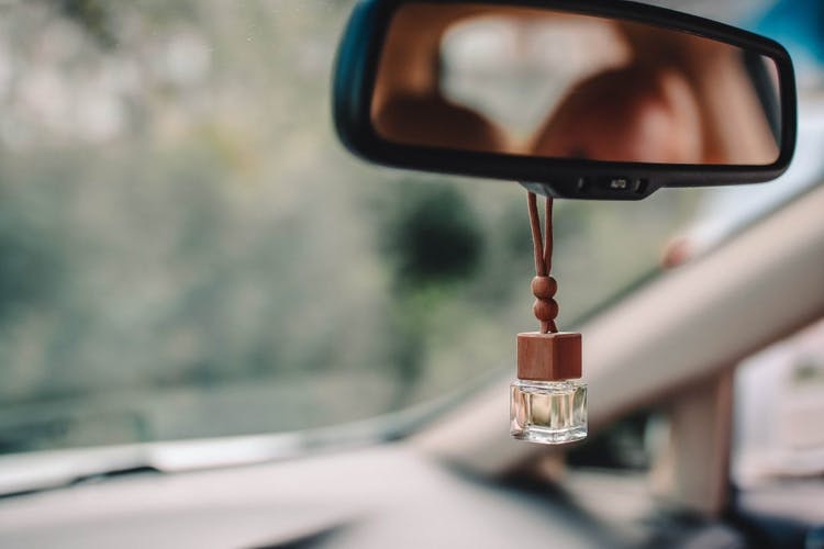 botella de esencia colgando del espejo central de un auto
