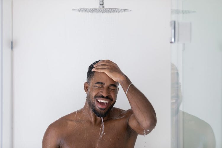 hombre bañándose bajo la ducha