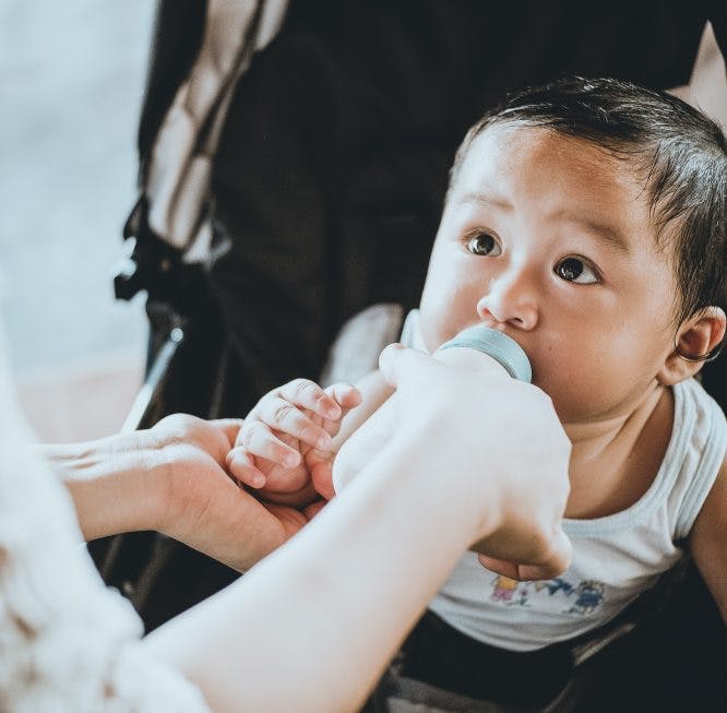 Un bebé siendo alimentado con biberón.