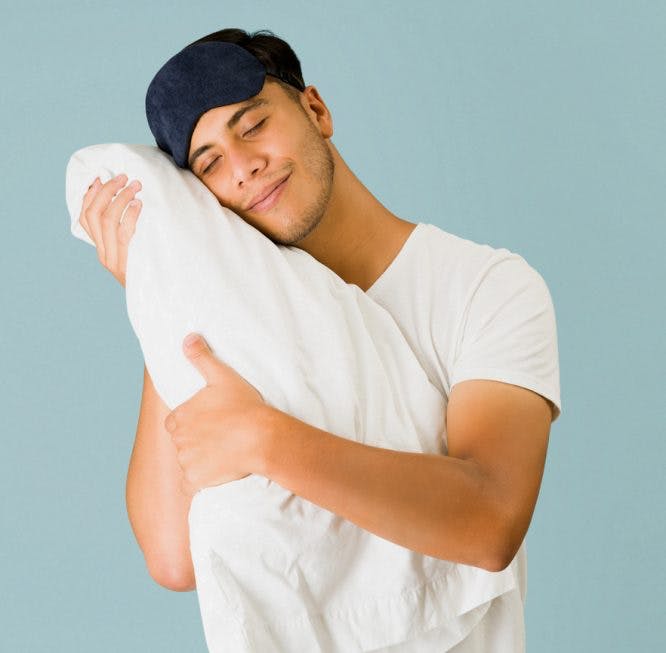 El hombre feliz abraza una almohada