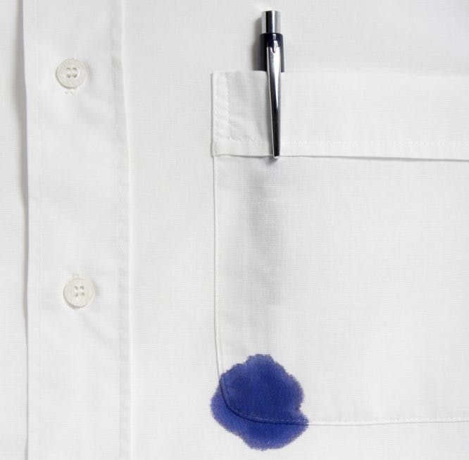 Mancha de bolígrafo azul en el bolsillo de una camisa blanca
