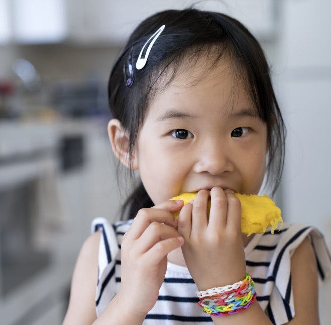 niña comiendo mango