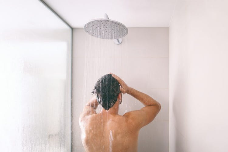 el hombre se baña en la ducha