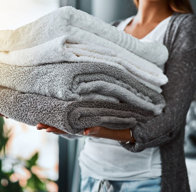 mujer cargando toallas dobladas
