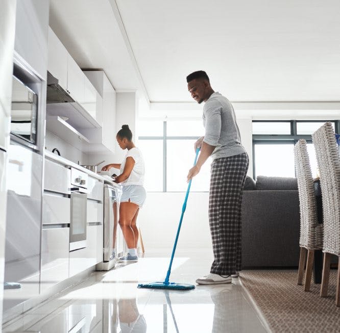pareja limpiando el piso de la cocina
