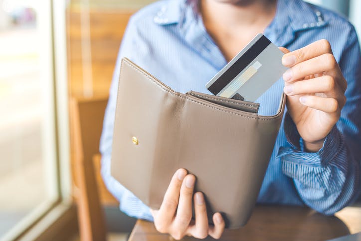 mujer sosteniendo una billetera de cuero transparente