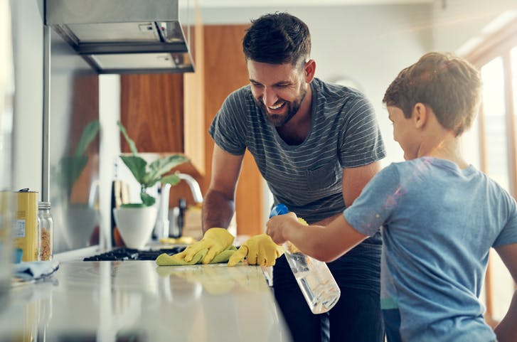 padre e hijo limpiando la encimera de la cocina