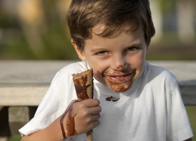 niño comiendo helado de chocolate