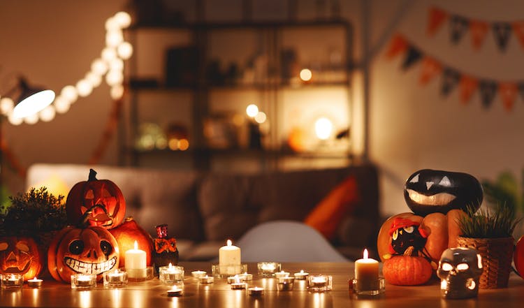 El interior de una casa con una mesa decorada con velas y con un tema de Halloween.