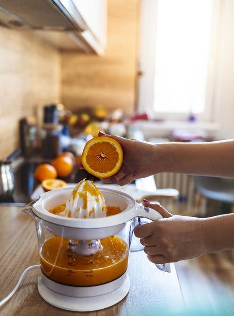 exprimidor eléctrico con naranjas